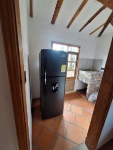 a kitchen with a black refrigerator in a room at Oasis Campestre in Sáchica