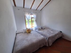 a bedroom with two beds and a window at Oasis Campestre in Sáchica