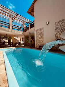 a swimming pool with a fountain in a house at Pousada Sereias de Maragogi in Ponta do Mangue
