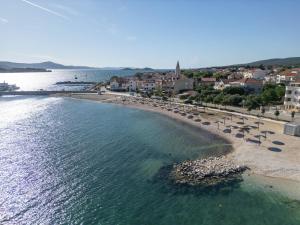 a beach with chairs and umbrellas and the water at Torretta Palace Hotel in Turanj