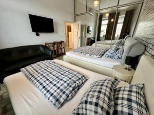 a bedroom with two beds and a tv and a couch at Royal City Centre Apartment - 2 Bedrooms 72 m2 - AC - Balcony - Coffee Machine - Washer - Dryer -Parking available Free public or Paid Private for 20 euro per stay Please read our emails in Poprad