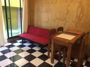 una habitación con un banco rojo y una mesa en Kapai Departamentos de Turismo en Valdivia
