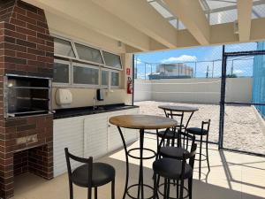 a kitchen with two tables and chairs in a building at Condomínio Club Resort 2 quartos com ar na melhor da Aruana in Aracaju