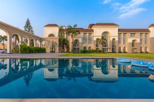 an exterior view of a mansion with a swimming pool at Ranveer The Garden Resort in Haldwāni