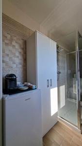 ein weißer Kühlschrank in einer Küche mit Dusche in der Unterkunft CasaAmena in Nardò