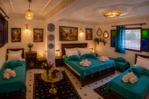 a bedroom with two green beds and a table at Riad T-A-J Fès Crown in Fez +60 photos
