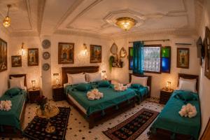 a bedroom with two beds with green sheets at Riad T-A-J Fès Crown in Fez