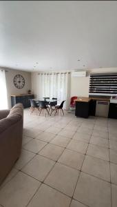a living room with a couch and tables and a clock at Le clos des voies in Ganges