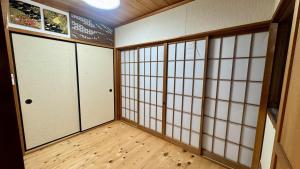 a room with white doors and wooden floors at Serene Hill Retreat in Nakatsugawa