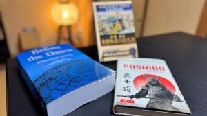 two books sitting on top of a table at Serene Hill Retreat in Nakatsugawa
