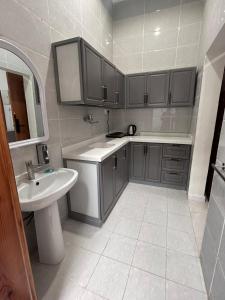a bathroom with a sink and a toilet and a sink at سرور للشقق المخدومة in Al Baha