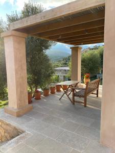 a wooden pergola with a bench on a patio at Studio Gaia in Kythira