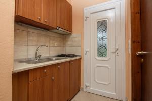 a small kitchen with a sink and a door at Qyra Studios in Skala Rachoniou +27 photos