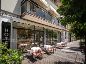a patio with tables and chairs in front of a building at Hotel Central Giacomini in Salò