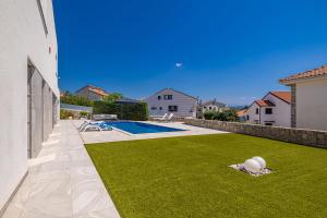 a backyard with a lawn and a swimming pool at Villa SIA with private pool in Krk