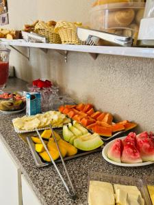 a buffet of fruit and vegetables on plates on a counter at Pousada Sereias de Maragogi in Ponta do Mangue