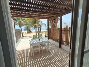 a patio with a table and chairs and the beach at Vilas Praia de Chaves SEA VIEW sol y mar in Rabil
