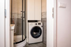 a washer and dryer in a small bathroom at The white Nest Apartment AC & Balcony in Bratislava