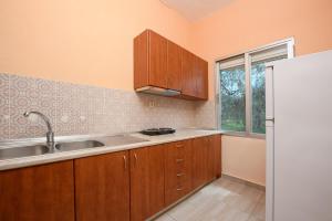 a kitchen with wooden cabinets and a white refrigerator at Qyra Studios in Skala Rachoniou