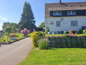 a house with a fence and flowers in the yard at Ferienwohnung Heidi in Selb