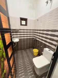 a bathroom with a toilet and a sink at Baylio Homestay in Kappil