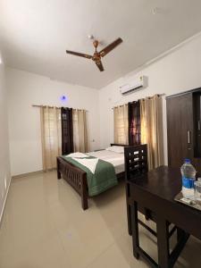 a bedroom with a bed and a ceiling fan at Baylio Homestay in Kappil