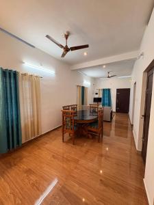 a living room with a dining room table and a ceiling fan at Baylio Homestay in Kappil