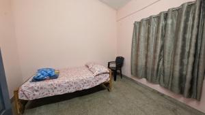 a small room with a small bed and a window at Eons riverdale in Kottayam