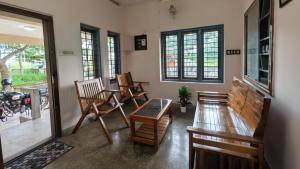 a room with chairs and a table and windows at Eons riverdale in Kottayam