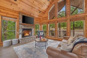 a living room with a fireplace in a log cabin at Twilight Pines - Dreamy Cabin w Hot Tub & optional Kids Loft in Broken Bow