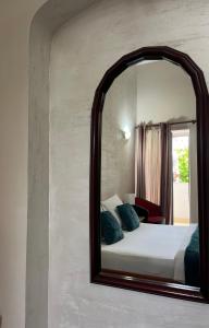 a mirror on a wall with a bed in a room at Apartments Skadarlija in Belgrade