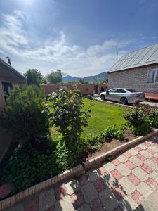 a yard with a car parked in a driveway at Bereke guest house in Bokonbayevo