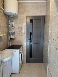 a bathroom with a washing machine and a sink at Bereke guest house in Bokonbayevo