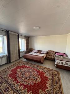 a bedroom with a bed and a rug at Bereke guest house in Bokonbayevo