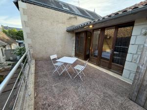 a patio with a table and chairs next to a building at Les Remparts T2 et T3 2 Etoiles in La Roche-Posay