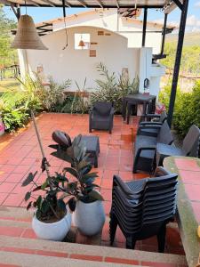 a patio with a bunch of chairs and plants at Villa Matilde in Curití +8 photos