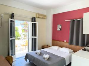 a bedroom with a bed and a red wall at Villa Markos in Perissa +107 photos