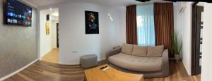 a living room with a chair and a table at Garden vibe apartament in Luduş