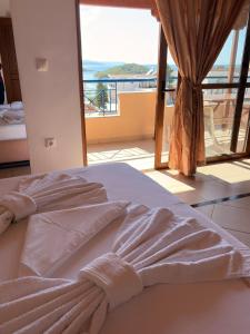 a bed in a room with a large window at Biraci Residence in Ksamil