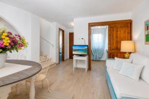 a living room with a couch and a table at Caprifogli Townhouse Close to the Beach in Baja Sardinia