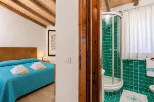 a bedroom with a bed and a shower and a tub at Caprifogli Townhouse Close to the Beach in Baja Sardinia +16 photos