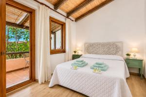 a bedroom with a bed with two towels on it at Caprifogli Townhouse Close to the Beach in Baja Sardinia