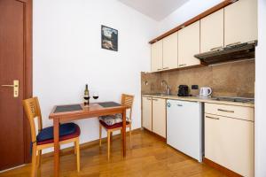 a kitchen with a table and a small table with chairs at Net in Rafailovici