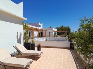 a patio with two chairs and a house at Villa Daba By Zelia in Ghazoua
