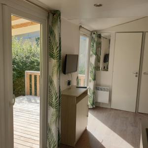 a living room with a television and a sliding glass door at Camping de Bourges in Bourges