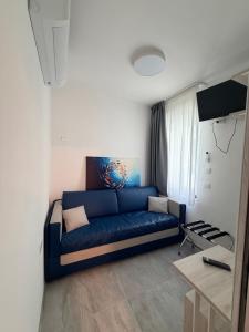 a living room with a blue couch in a room at Hotel Villa Mirella in Grado