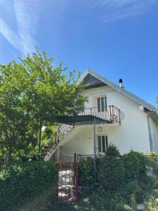 a white house with a staircase in front of it at Vikendica Vrba in Gacko