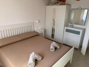 a bedroom with a bed with two slippers on it at Villa Anna in Costa Rei