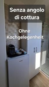 ein kleiner weißer Kühlschrank in einem Raum mit einem Schild in der Unterkunft CasaAmena in Nardò + 11 Fotos