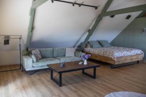 a living room with a couch and a coffee table at DuinDroom bovenappartement, Beverwijk in Beverwijk
